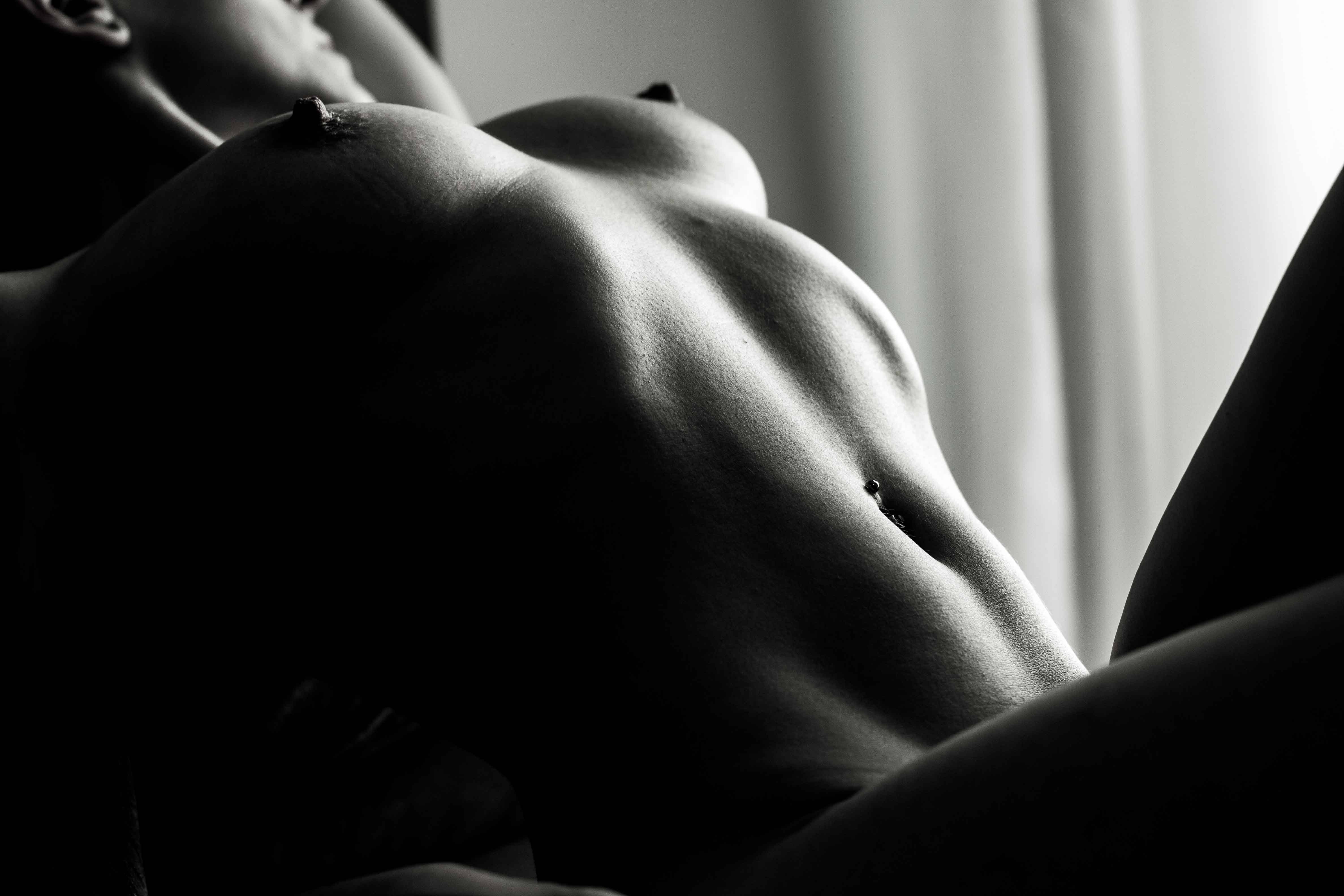 Nagie ciało kobiety na kanapie w świetle słońca